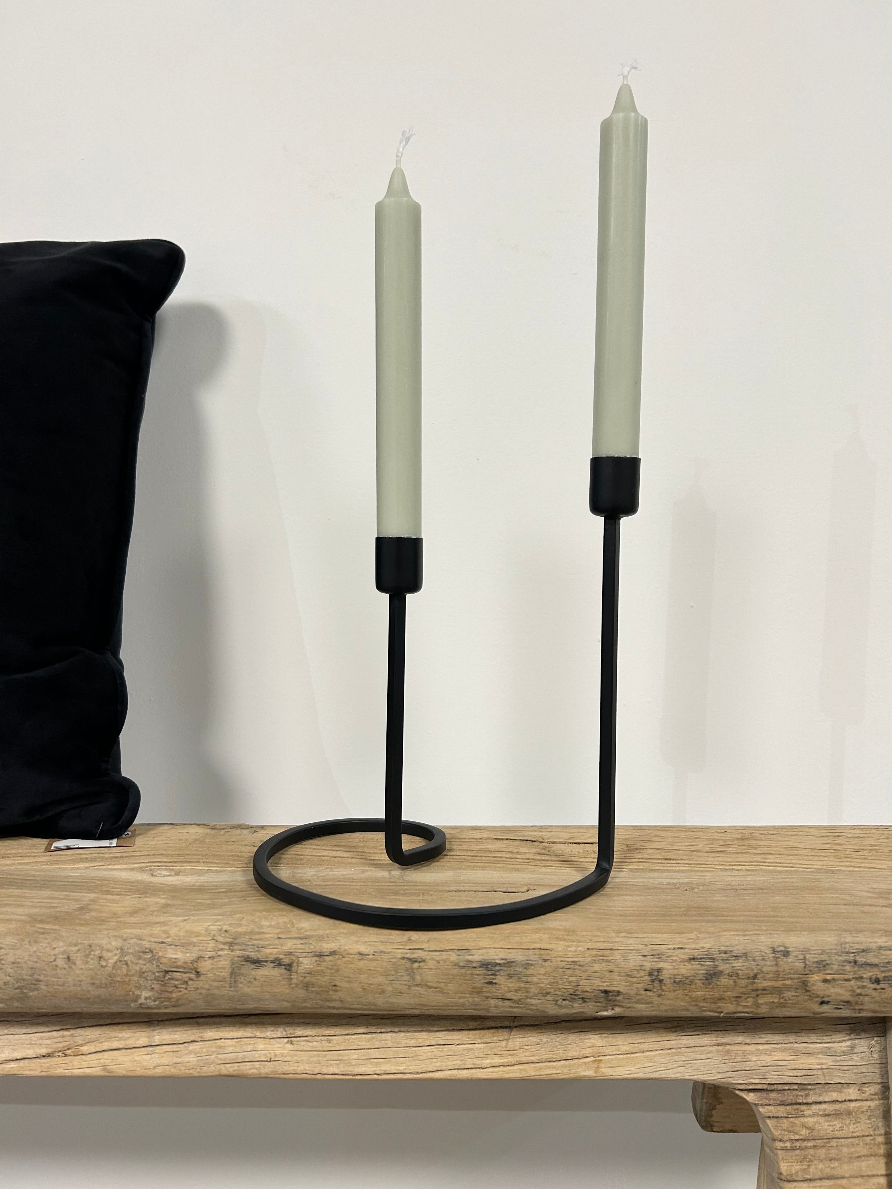 Bougeoir noir de style scandinave avec deux bougies chandelle vert pastel, posé sur un banc en bois naturel Inde