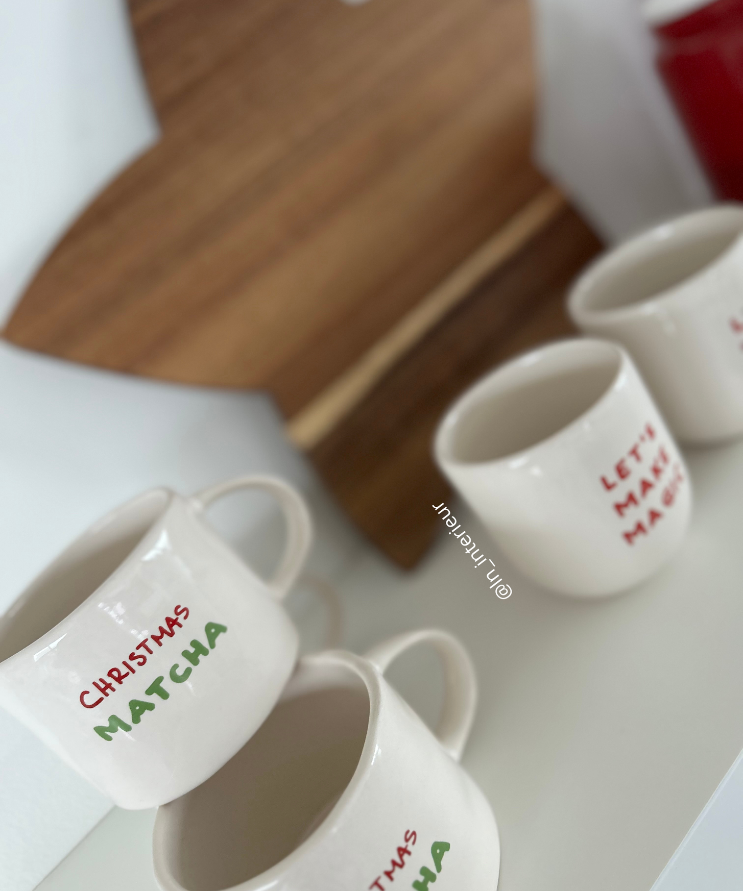 Tasses Christmas matcha et mugs de noël sur une étagère blanche avec une planche en bois en forme d'étoile