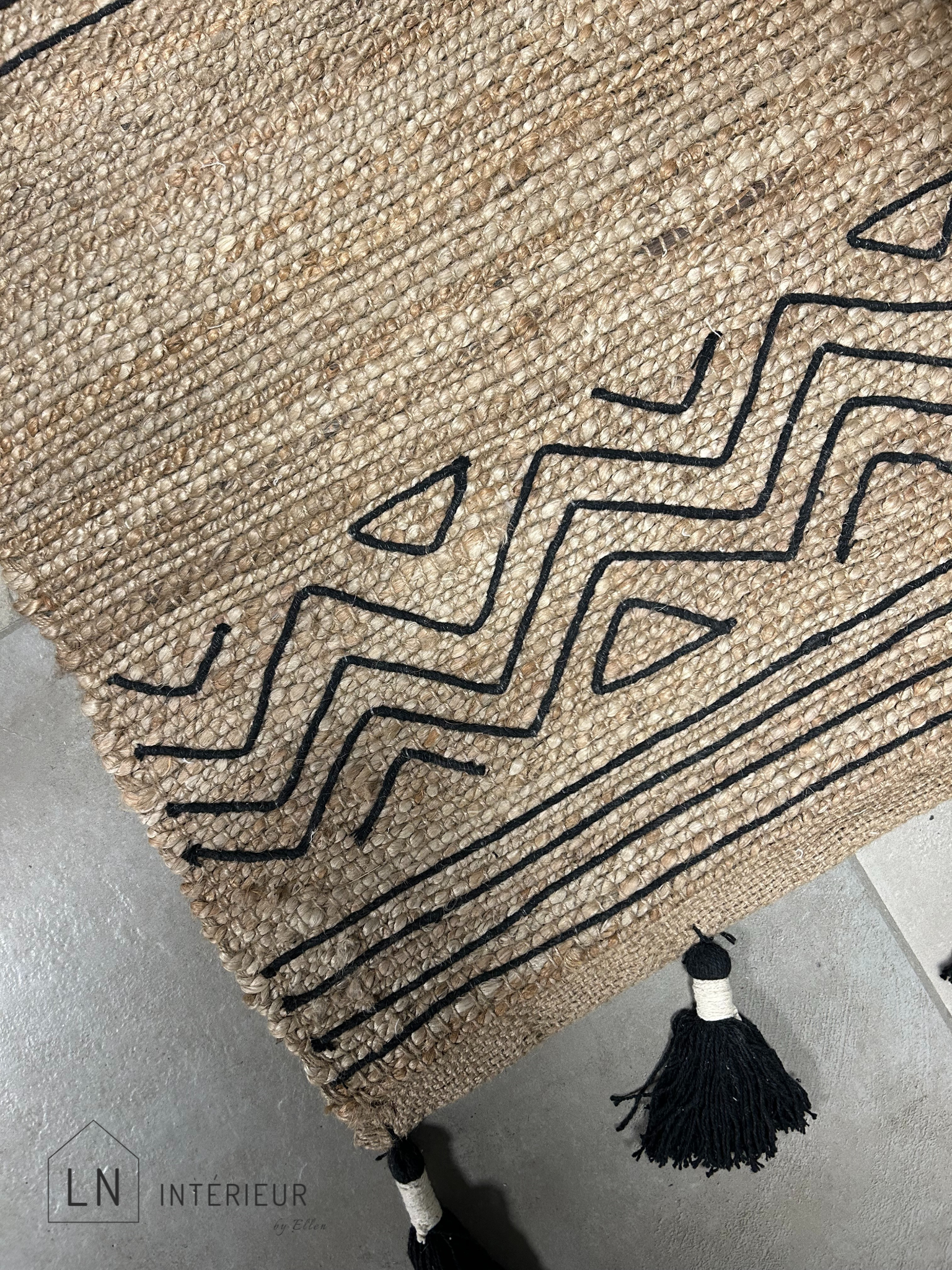 tapis de couloir ou descente de lit noir et naturel avec pompons dans un style ibiza