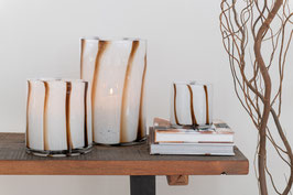 Une collection de vases et de bougeoirs en verre de couleur brun et blanc. Ils sont soufflés à la bouche